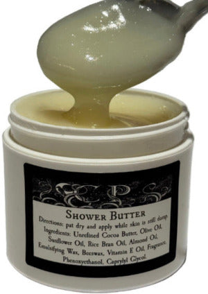 Jar of shower butter with a spoonful being lifted out, showing its texture.